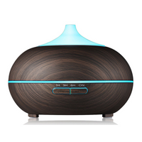 Natural oak humidifier diffusing a fine cool mist on a nightstand