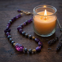 Purple Amethyst Chunky Necklace next to a warm glowing candle and dried lavender on a dark walnut tabletop